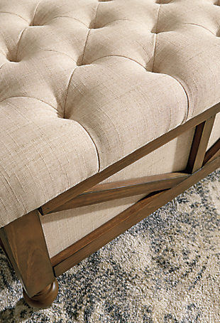 Chic, streamlined and ultra mobile, the Kyleman storage ottoman is utterly in vogue. The roomy storage compartment keeps blankets, remote controls and other odds and ends out of sight but easily accessible. Sumptuous tufting adds so much allure. All this along with smooth-gliding casters that let the good times roll.Made with solid wood | Neutral polyester upholstery | Tufted top | Foam cushion | Flip-top reveals storage compartment | Wood legs with brown finish and smooth-gliding casters | Assembly required | Estimated Assembly Time: 15 Minutes