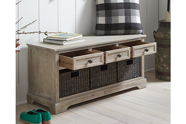 The wonderfully weathered Oslember storage bench makes what’s old fresh and new. Packed with possibilities, it’s sure to be a welcome addition everywhere from the entryway to the bedroom, home office, kitchen or mudroom. Quality construction includes three smooth-gliding drawers and a trio of woven baskets that make handy catchalls.Made of veneer, wood and engineered wood | Light brown finish | Antique bronze-tone finished metal drawer pulls | 3 smooth-gliding drawers | 3 removable woven baskets