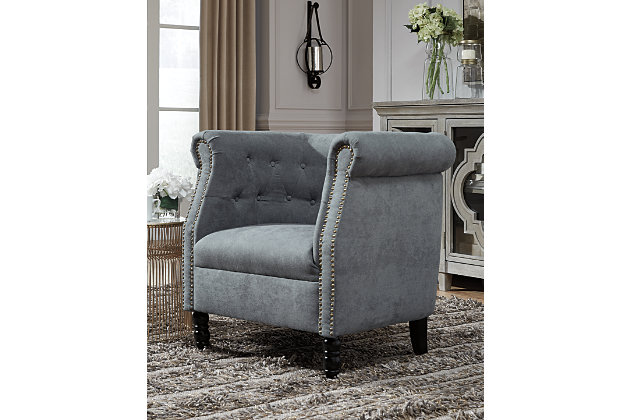 Bring a European style to your home with the Jacquelyne accent chair. The slate blue color is sophisticated and subtle while the tufted barrel back and turned wood legs evoke an air of exclusivity. Make your space your own private club with this uptown piece.Button tufted barrel back | Attached seat cushion with spring construction | Foam cushions wrapped in thick poly fiber | Slate blue polyester upholstery | Nailhead detail | Wood turned legs in black finish | Estimated Assembly Time: 30 Minutes