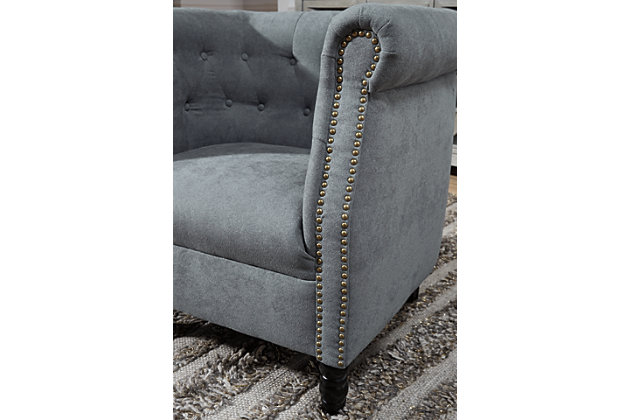Bring a European style to your home with the Jacquelyne accent chair. The slate blue color is sophisticated and subtle while the tufted barrel back and turned wood legs evoke an air of exclusivity. Make your space your own private club with this uptown piece.Button tufted barrel back | Attached seat cushion with spring construction | Foam cushions wrapped in thick poly fiber | Slate blue polyester upholstery | Nailhead detail | Wood turned legs in black finish | Estimated Assembly Time: 30 Minutes