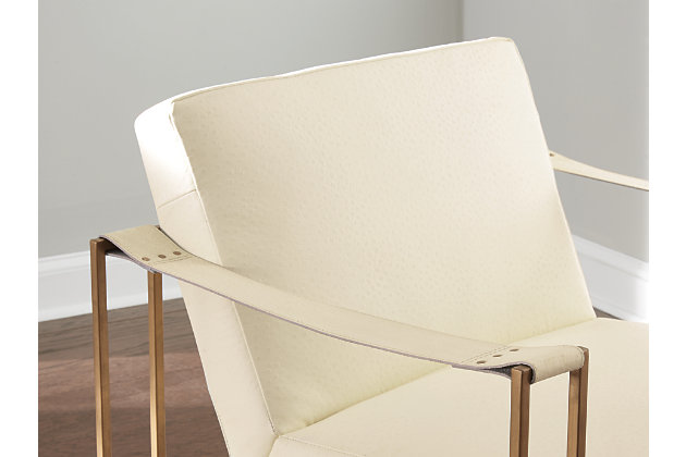 Less is so much more with the ultra-cool Kleemore accent chair. A mastery in open-concept living, this chair with sturdy metal base is enriched with thickly padded box cushions wrapped in a cream leather with ostrich patterned embossing. Leather armrests are a strapping touch.Made of metal in goldtone finish | Tight seat and back | Upholstered in cream ostrich patterned embossed leather | Estimated Assembly Time: 15 Minutes