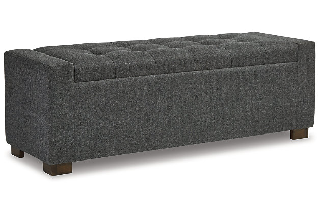 Whether gracing a front entry or living room, or placed at the foot of the bed, the Cortwell upholstered storage bench is loaded with flair. Tufted cushioned seat with hinge reveals an ample storage compartment for this, that and the other. Gorgeous gray fabric is the epitome of neutral sophistication.Polyester upholstery in gray | Wood legs with brown finish | Tufted seat cushion | Hinged seat | Interior storage | Estimated Assembly Time: 30 Minutes