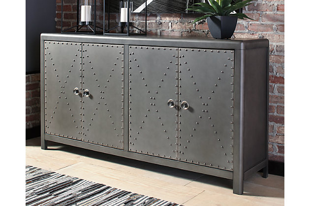 Whether storing plates and linens in the dining room, supplies in the home office or serving as a TV console, the Rock Ridge 4-door accent cabinet works a modern industrial look loaded with versatility. Antique gunmetal finish—punctuated with nailhead accents—wows with retro-chic charm.Made of solid and engineered wood | Black finished metal door pulls | Nailhead accents | 4 cabinet doors | 2 adjustable shelves | Estimated Assembly Time: 30 Minutes