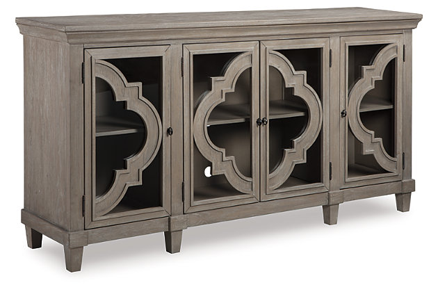 Wowing with exquisite quatrefoil framing, made all the more dramatic with the contrast of clear glass, the Fossil Ridge 4-door cabinet serves up an easy-elegant aesthetic sure to satisfy. The light and lovely finish brings a relaxed sensibility to the scene.Made of solid and engineered wood | Gray distressed finish | Black-finished metal hardware | 4 cabinet doors with glass inlays | 3 adjustable shelves | Excluded from promotional discounts and coupons | Estimated Assembly Time: 30 Minutes