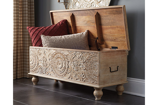 Merging practical storage with an exotic sense of flair, the Fossil Ridge storage bench stands out from the crowd in an intriguing way. Grainy wood is beautified with an antique white finish. Ornamental medallion carvings are pure artistry.Made of solid wood | Antique white finish | Black metal handles | Hand-carved styling | Hinged top with underlying storage | Estimated Assembly Time: 15 Minutes