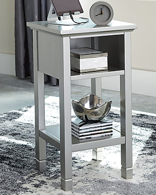 Your home called. It asked for the Marnville accent table. Understated silvertone finish is simply irresistible, elevating the silhouette with elegance. Clean lines maintain the contemporary aesthetic you crave. Open cubby and bottom shelf provide storage for essentials and decor. Power up your devices with USB ports. How’s that for form and function?Made of wood, engineered wood and veneers | Silvertone finish | 1 open cubby and bottom shelf | 2 USB charging ports | Power cord included; UL Listed | Estimated Assembly Time: 30 Minutes