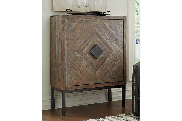 A swanky essential for the entertainer, the Premridge bar cabinet brings back cocktail hour in high style. Behind the diamond inlay pattern doors with shapely wooden pulls you’ll find dual racks for up to 16 wine bottles, holders for 27 standard wine glasses and an adjustable shelf to serve your needs. Pairing of antique gray wood and black finished metal is so pleasing to the palette.Made of wood, engineered wood and metal | Antique gray finish and black finished metal | 2 doors with diamond inlay pattern and wooden pulls | 2 slotted shelves hold 16 bottles | Rack holds 27 stemmed glasses | Adjustable shelf | Assembly required | Estimated Assembly Time: 30 Minutes