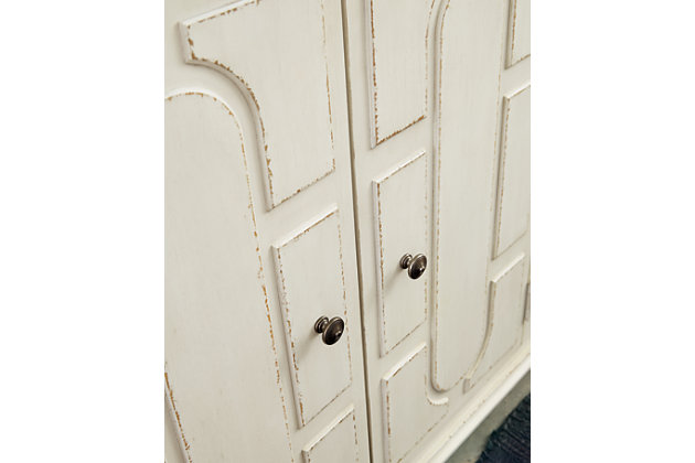 Whether your style is cottage chic, boho inspired or uniquely eclectic, the Roranville accent cabinet is sure to look right at home. Standout elements include raised panel door fronts that are a work of art. Wonderfully timeworn in antique white, this 4-door cabinet is topped with a warm brown finish for two-tone interest. Two adjustable shelves add to its practicality.Made of veneer, wood and engineered wood | Antique white and brown finish | 4 doors | 2 adjustable shelves | Bronze-tone metal door pulls | Assembly required | Estimated Assembly Time: 45 Minutes