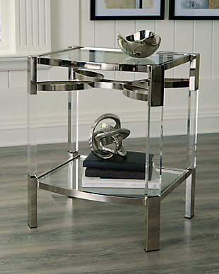 If you love the idea of total transparency, the Chaseton accent table is surely a sight for sore eyes. Crafted of clear acrylic, the glass top and open glass shelf is beautifully on trend. Sleek chrome plated metal legs with clear acrylic accents add a touch of elegance to your mid-mod vibe.Clear acrylic, metal and glass | Lower open shelf | Chrome plated metal and clear acrylic legs | Assembly required | Estimated Assembly Time: 30 Minutes
