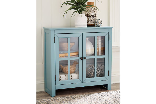 Function and style merge perfectly with this Nalinwood accent cabinet. Constructed of wood in a teal finish, the accent cabinet adds a pop of color. Two doors and an adjustable shelf make for multiple storage solutions. Pewter finished metal door pulls add a finishing touch and a lattice door front with clear inset glass allows you to show off what you store.Made of solid and engineered wood in teal finish | Lattice door front with inset clear glass | Metal door pull in black | 2 doors and 1 adjustable shelf | Assembly required | Estimated Assembly Time: 15 Minutes