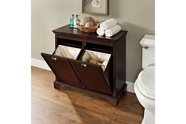 Not quite ready for the inconvenience and expense of a complete bathroom remodel? This line of stylish storage solutions will help you create the bathroom of your dreams.  the high-end design of this laundry hamper keeps your linens and its true purpose cleverly under wraps. Drop-front design gives access to dual-sided, removable bags making sorting and carrying a breeze. At home in the tightest or most spacious bath, its compact size allows you to live large in small places.Made of wood, veneers and engineered wood | Steel-tone metal accents | Louvered doors | Dual compartments for easy separating | Removable cloth bags | Assembly required