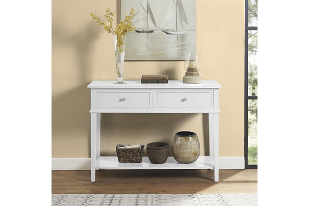 Whether dressing up your living room or organizing your entryway, this console table in white is loaded with charm and potential. Sure to look right at home in modern farmhouse and cottage chic settings, this accent table with two drawers and a display shelf is compact yet accommodating.Made of wood and engineered wood | 2 drawers | Fixed shelf | Assembly required