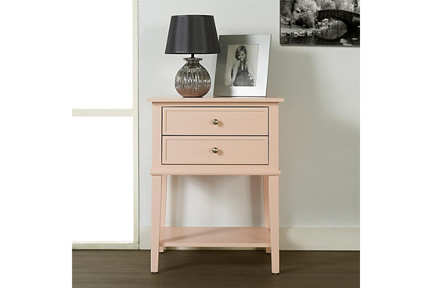 Whether flanking a sofa or chair or serving as a dreamy nightstand, this accent table in pink is loaded with charm and potential. Sure to look right at home in modern farmhouse and cottage chic settings, this accent table with two drawers and a display shelf is compact yet accommodating.Made of wood and engineered wood | 2 drawers | Fixed shelf | Assembly required