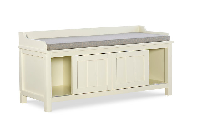Whether gracing a front entry, living room, kitchen or mudroom, this storage bench is loaded with vintage charm. The bench’s plush cushion adds comfort to the seat, and ample bottom storage offers space for shoes, books and catchalls. Sliding doors keep your items hidden from sight, while the cream finish is an easy addition to any space.Made of wood, engineered wood, foam and fabric | Antiqued cream color finish | 2 sliding doors | 1 fixed shelf | Foam-filled cushion in gray polyester linen fabric | Assembly required
