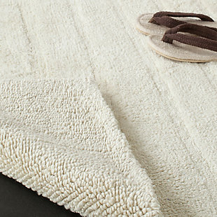 Add a lavish spa feel to the bath with this soft, fabulously functional, striped hand-tufted bath mat. Indulge in the luxury of plush and absorbent cotton every time you step on this reversible bath mat. One side is ribbed in elegantly simple vertical bands, while the other side is solid texture, all crafted from a deluxe 3000 grams of pure cotton.Set of 2 | 100% Indian cotton | Hand-tufted | Vanilla | Reversible (no backing) | Rug pad recommended to avoid shifting and sliding | Imported