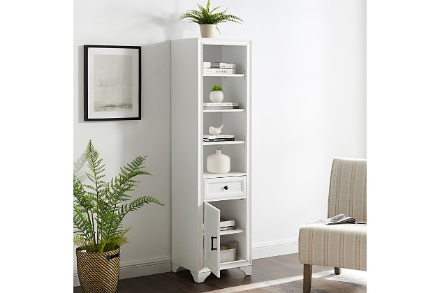 Bring a sense of order to your bathroom with this chic linen cabinet. Designed to add much-needed bathroom storage, its tiered shelves, full-extension drawer and roomy cabinet provide an elegant use of space. At home in the tightest or most spacious bath, its compact footprint allows you to live large in small places.Pine frame with birch veneer | White finish | Metal hardware with distressed brass-tone finish | Cabinet space | Full-extension drawer | 3 shelves | Assembly required