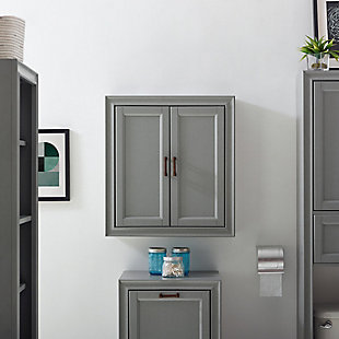 Bring a sense of order to your bathroom with this chic wall cabinet. Designed to add much-needed bathroom storage, its craftsman style doors and roomy cabinet provide an elegant use of space. At home in the tightest or most spacious bath, its compact size allows you to live large in small places.Pine frame with birch veneer | Gray finish | Metal hardware with distressed brass-tone finish | Double door cabinet space | Ready to hang | Assembly required