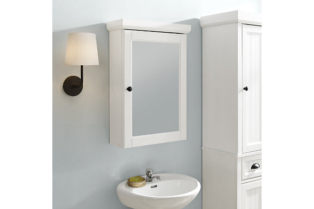 Bring a sense of order to your bathroom with this chic medicine cabinet. Designed to add appeal while hiding its true function, this mirrored cabinet with three shelves provides an elegant use of space. At home in the tightest or most spacious bath, its compact size allows you to live large in small places.Pine frame | White finish | Mirrored cabinet with crown moulding and metal hardware | Ready to hang | Assembly required
