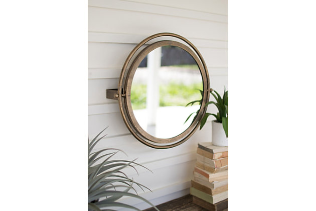 Reminiscent of a schooner port hole, this metal mirror boasts double frames and the ability to swivel, allowing small and tall people to check their look. Also excels at refracting light!Mirrored glass | Goldtone metal frame | Tiltable design | Ready to hang