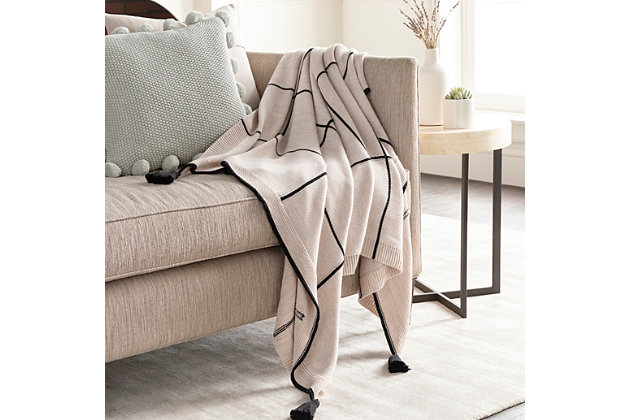 That's a wrap. With its sense of snuggly softness and posh palette, this designer cotton throw blanket is truly irresistible. Flirty fringe takes the aesthetic from simple to simply sensational.Made of cotton | For indoor/outdoor use | UV resistant; water resistant | Tassel accent | Spot clean only | Imported