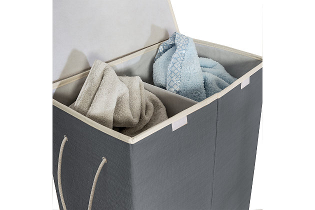 Make laundry day more efficient by pre-sorting your dirty laundry with this 2-Compartment Collapsible Sorting Hamper. Lights in one side and darks in the other let you grab and get started quickly. Handles allow you to move it easily around the room and it folds completely flat when it’s not in use. A tight Velcro lid allows you to literally keep a lid on overflowing laundry, but it won’t keep a lid on the excitement you’ll have when laundry day is over.Features 2 compartments for easy clothes sorting | Durable resin exterior in neutral, cool grey with breathable liner | Handles provide mobility | Folds flat for easy storage when not in use