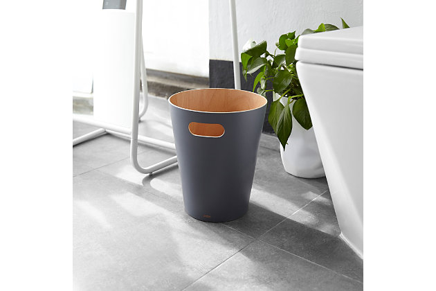 Add modern, contemporary style to a basic household essential. Introducing Woodrow Waste Can by Umbra Made of natural treated wood curved into a can shape, Woodrow warms and grounds a room, even though its core function is being a garbage can. Use Woodrow to add a modern, subtle decorative touch to your powder room, bathroom, office, study or wherever you choose to put it. This two-tone waste can fills any room with modern contemporary aesthetic and makes a great home office wastebasket or office recycling container. Woodrow is available in a wide range of finishes, all come with a natural wood finish on the interior. It features integrated handles that allow for easy transport and disposal of waste or recycling. Woodrow measures 9” diameter x 11” and has a capacity of 2 gallons (7.5 L), which is great for small spaces.CLEAN, MODERN DESIGN: Made of treated wood, Woodrow has a natural wood interior and is available in a wide-range of exterior finishes | EASY TO TRANSPORT: Woodrow features integrated handles for easy transport and disposal of its contents | FUNCTIONAL & DURABLE: This modern trash can's open-top design features durable, high-quality construction | 2 GALLON CAPACITY: Woodrow has a 2-gallon (7.5 L) capacity that is perfect even in small spaces
