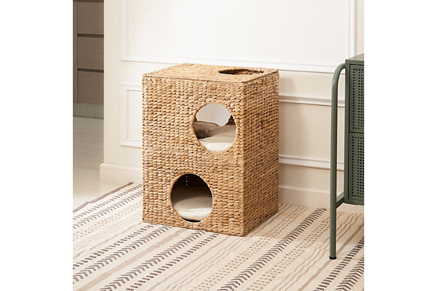 This handwoven water hyacinth cat house with cushions is not only perfect for your cat but is also a piece of rustic decor for your home. Woven from eco-friendly natural water hyacinth with thick braids and a fishbone weave, and supported by a rustproof iron frame, it's strong and durable. Five holes and two stories with soft and comfortable cushions offer the most wonderful place for your cat to play and enjoy. This cat house is also lightweight, so it can be easily moved from room to room. Its natural golden and toffee-colored finish brings a soothing, natural feel to your home.Made of natural water hyacinth and iron | Natural finish | Rustproof frame | 5 holes | Includes 2 cushions | Eco-friendly | Weight capacity 30 pounds | No assembly required