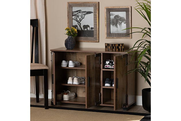 Combining elements of both industrial and farmhouse design, the Cyrille shoe cabinet is a unique addition to any entryway. This shoe cabinet features a rustic finish, giving the piece a cozy, traditional feel. Six shelves provide space to store up to 12 pairs of shoes. Antiqued silvertone corner brackets accentuated with studs lend an industrial touch, while long handles and block feet convey contemporary style.Made of engineered wood, metal, and PVC | Rustic brown finish | Six shelves provide storage space for 12 pairs of shoes | Metallic corner brackets with studs | Assembly required