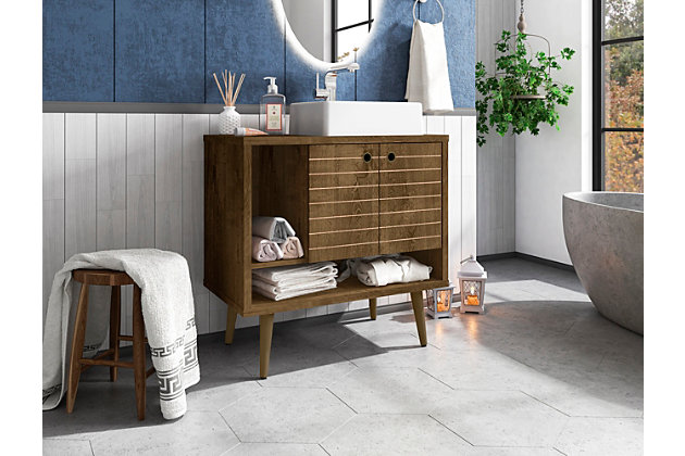 Refresh your bathroom or powder room space with the Liberty vanity. This vanity offers storage and style all at once. Beautiful splayed legs and detailed cabinet doors are seamless and versatile, easily blending with any interior design. Cabinet doors conceal shelving space to help arrange personal items, cleaning supplies and more, while a lower open shelf is great for tucking away extra toiletries, diffusers or candles. Open side storage stashes away extra supplies and displays towels, giving your bathroom that hotel feel.Freestanding vanity with sink for bathroom usage | Rustic brown finish | Made with wood | Sink made with faux marble; vessel faucet installation type | Splayed legs made with solid wood for extra durability | Includes 2 open shelves for storage and 2 doors concealing water pipes | 90-degree open door style with soft-close features and ring cutout knobs with sleek lateral line indent design | Assembly required