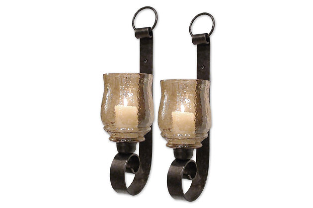 Enjoy the flickering light of a candle through transparent amber glass, and softly illuminate the room to make it feel cozy. These beautiful sconces are ideal for use in an entrance, hallway or bedroom, and come ready to use with two candles included.Set of 2 | Made of iron and glass | Metal frame with antiqued bronze-tone finish | Glass hurricane with transparent amber finish | 2 white 2" x 3" candles included | Indoor use only | Ready to hang