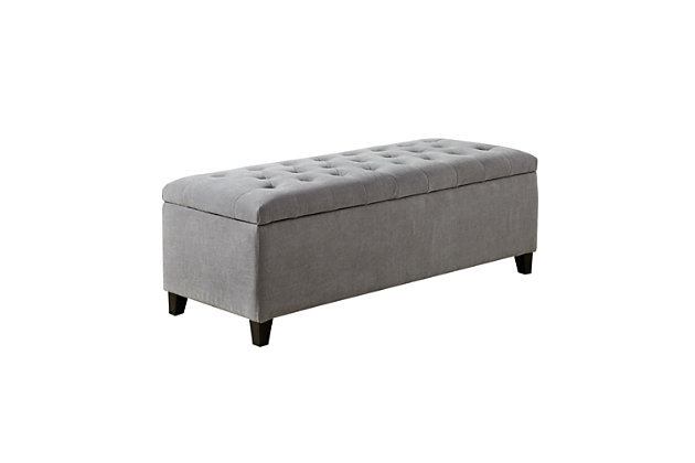 The modern Shandra Storage Bench organizes linens and impresses with its stylish details. Featuring an elegant gray fabric with rich black legs, it provides the perfect functional finishing touch for your space. Made with wood | Legs with black finish | Polyester upholstery | High-density foam filling | Button-tufted detailing | Interior storage