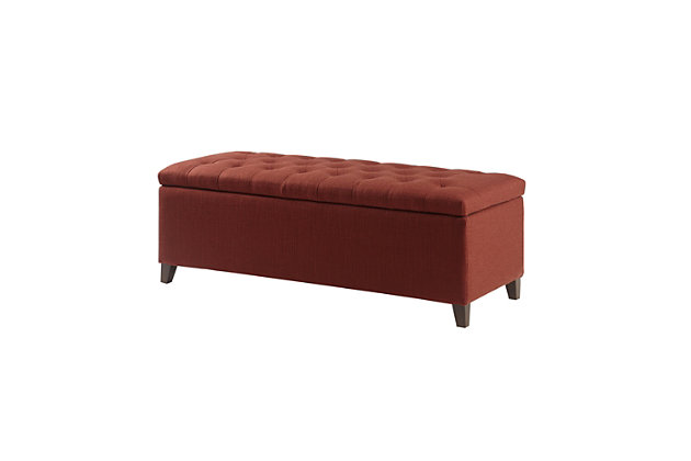 The modern Shandra Storage Bench organizes linens and impresses with its stylish details. Featuring an elegant rust red fabric with rich espresso-hued legs, it provides the perfect functional finishing touch for your space. Made with wood | Legs with espresso-hued finish | Polyester/acrylic upholstery | High-density foam filling | Button-tufted detailing | Interior storage