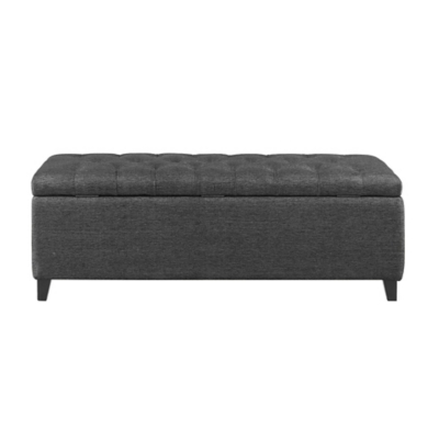 Side view of the dark grey upholstered storage bench with tufted top and short legs