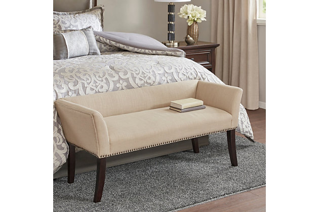 Accent your home with the simple elegance of the Madison Park Welburn Accent Bench. Upholstered in a cream-hued fabric, it features a low back and flared arms that create a sleek and sophisticated look. Bronze-tone nailhead trim adds elegance, while the wood finish complements its upholstery. Perfect for your bedroom or living room, this upholstered bench provides a chic update to your home decor. Made with wood | Legs with Morocco finish | Polyester/linen upholstery | Foam filling | Bronze-tone nailhead trim | Low back and arms