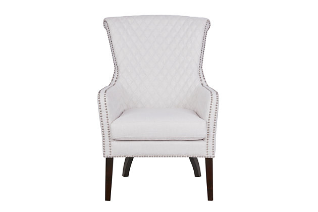 Relax in the luxurious style of the Madison Park Heston Accent Chair. This modern accent chair puts a twist on a classic design with its quilted back and elegant silvertone studs lining the arms and seat. A high-density foam cushion fills the seat for exceptional comfort, while solid wood legs with a Morocco finish provide excellent support.Made with wood | Legs with Morocco finish | Polyester upholstery | High-density foam filling | Quilted back and inside arms | Silvertone nailhead trim | Assembly required