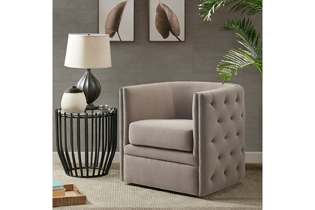 Update your living room with the rich style of the Madison Park Capstone Swivel Chair. A curved back and arms frame the wide seat, while brass-tone nailhead trim adds a classic touch. Gray upholstery looks cool and cozy, while the swivel feature allows the lounge chair to rotate on its base for ultimate versatility.Made with wood | Metal base with black finish | Polyester/rayon upholstery | Foam filling | Brass-tone nailhead trim | Swivel feature