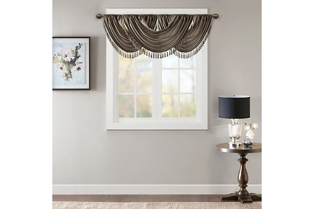Bring style and sophistication to your windows, with our Elena Waterfall window valance. This classy pewter valance showcases rich center draping details and a beautiful tassel trim, combined with the faux silk fabric for a rich sheen and stylish update. Features added lining and a rod pocket top finish; fits up to 1.25" diameter rod. Part of our decorative valance collection, this valance is perfect as a stylish addition to any small window or even better as a layering piece to dress up any window panel. This window valance is also OEKO-TEX certified, meaning it does not contain any harmful substances or chemicals, ensuring quality comfort and wellness. Multiple valances used to create this look.Imported | Faux silk luxe light sheen fabric window valance | Center waterfall drape design | Fits up 1.25" diameter rod | Tassel trim embellishment detailing | Oeko-tex certified, includes no harmful substances or chemicals (# bj025 173578) | Added lining for finish touch | Coordinating window panel available and sold separately | Machine washable for easy care