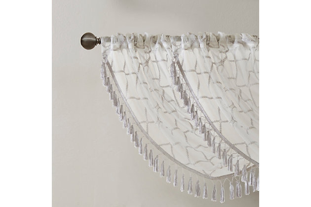 Madison Park’s Irina Diamond Sheer Waterfall Valance provides an alluring update to your home. An elegant diamond pattern is beautifully embroidered on a soft sheer fabric, adding grace and charm to your décor. The neutral colors and light fabric helps create a delicate look to soften any room, combined with the beautiful tassel trim and rich draping details, makes this the perfect dressing to any window. Complete the look with coordinating window panels, sold separately. Multiple valances used to create this look.Imported | All over diamond embroidery design | Lightweight sheer base fabric | Rod pocket top finish | Trim embellishment detailing | Center waterfall draping detail