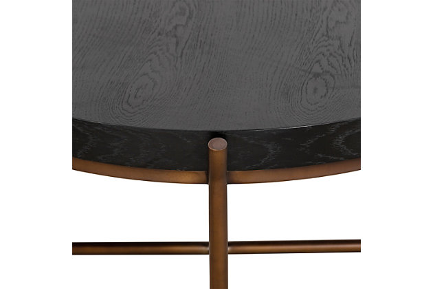 Update the decor of your home with the Sylvie brushed coffee table. The thick oak wood tabletop is wide and strong - capable of holding heavy ornamental objects or multiple personal items all at once. The round x-shape frame is built to carry an even amount of weight and can easily support the tabletop and any items placed on it. Put this in your living room, family room or bedroom - the possibilities are endless. The brushed black oak surface atop the bronze-tone base creates a chic look that is sure to last for many years to come.Made of oak wood and metal | Brushed black finish | X-shaped frame in bronze-tone finish | Simple to clean and easy to maintain; wipe clean | Assembly required