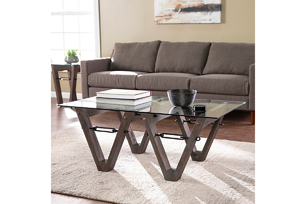 Give your living space an industrial edge with this unique coffee table. A spacious glass tabletop provides plenty of room for your magazines and a cup of coffee, while a reclaimed wood base adds a rustic feel to your home. Tuck this rectangular table between a pair of armchairs to accent your living space, or slide in front of your sofa as functional decor. Put a fresh spin on industrial design when you bring home this glass-top cocktail table.Made of wood, glass and iron | Reclaimed wood features natural splits and knots | Mixed, restored wood makes every item unique | Assembly required