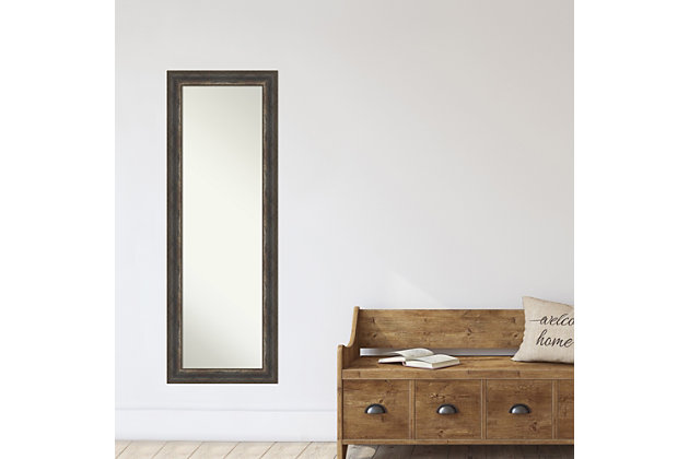 This high-quality full-length mirror complements your decor without the need for unsightly "over the door" brackets. Our On The Door Mirror comes with two hooks to hang directly on your door without additional anchors or brackets. With a 14 x 48" viewing area, it gives you a full image either on the back of a door or on the wall as a standard full-length mirror. This mirror features a black, grey, and bronze-toned frame reminiscent of charred, distressed wood with each edge finished in brushed shiny pewter. Amanti Art is headquartered in Madison, WI, and provides high-quality, handmade framed art, mirrors, and organization boards for your home improvement projects. Our home decor products are made using traditional custom framing techniques that give you the kind of quality you'd expect from your local frame shop. Because of our focus on workmanship, our products are used by architects, developers, interior designers, and homeowners alike to create beautiful functional living spaces.The alta rustic char frame is a black, grey, and bronze-toned frame reminiscent of charred, distressed wood with each edge finished in brushed shiny pewter. | This mirror works perfectly as a door mirror, full size mirror or large mirror on the wall. This mirror itself is not beveled, for full use of the reflective area. | All amanti art wall mirrors are finished with a paper backing to prevent moisture and dust buildup. | Each mirror has durable d rings attached to the back along with 2 hanging hooks and nails to tap directly into your door or wall. It can be hung on door or horizontally/vertically on the wall. | Amanti art custom frames decorative mirrors and assembles each piece to order in madison, wi.