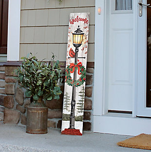 Spruce up your front porch with this rustic farmhouse welcome sign as you ring in the holidays. A beautiful lamppost adorns the indoor/outdoor Porch Board™, complete with a classic Christmas wreath and cardinal. This unique door sign is sure to turn heads while adding style and decor to your surroundings.Made of engineered wood | Weatherproof | Suitable for indoor/outdoor use | No assembly required | Made in the USA
