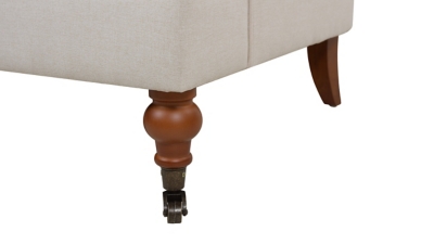 close-up of leg and caster hardware on beige sofa