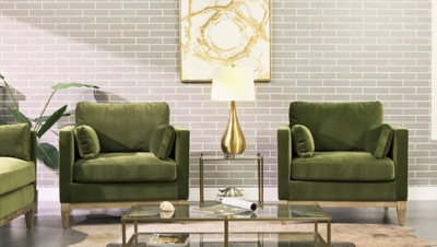 green velvet armchairs in living room setting with lamp table and decor