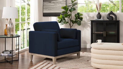 navy blue armchair in living room setting with plants and cabinet