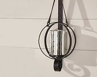 Love a rustically refined sense of style? You’re sure to be hooked on the one-of-a-kind Despina wall sconce. Luminous mercury glass hurricane lamp is encircled by hammered metal rings and secured by a strapping leather strap and metal wall brace.Made of mercury glass, metal and leather | Holds 1 pillar candle (not included) | Keyhole bracket | Clean with a soft, dry cloth