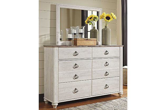 The Willowton dresser and mirror set is the ultimate statement piece for a coastal cottage or shabby chic inspired retreat. Whitewashed finish on the drawers and sides is wonderfully easy on the eyes. Paired with the unique faux plank top, it’s a driftwoody look that has our minds drifting away to beachy-keen escapes.Includes dresser and mirror | Made of engineered wood (MDF/particleboard) and decorative laminate | Whitewash replicated worn through paint with authentic touch | Replicated wood grained block pattern with authentic touch | Antiqued brass-tone knocker hardware | 6 smooth-gliding drawers | Mirror attaches to back of dresser | Safety is a top priority, clothing storage units are designed to meet the most current standard for stability, ASTM F 2057 (ASTM International) | Drawers extend out to accommodate maximum access to drawer interior while maintaining safety | Assembly required | Estimated Assembly Time: 5 Minutes