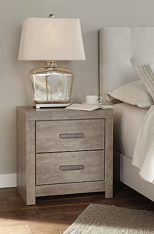 The Culverbach nightstand’s weathered driftwood finish evokes such an ethereal vibe—exactly what you need for your serene master suite. Clean lines and simple yet substantial hardware make for a timeless look you’ll love living with for years to come. Two spacious drawers offer ample storage for all the bedside essentials, while its USB ports make charging wireless devices a breeze.Made of engineered wood and decorative laminate | Warm vintage gray with subtle pearl effect over replicated cherry grain | Pewter-tone hardware | 2 smooth-gliding drawers with replicated linen lining | 2 USB charging ports | Power cord included; UL Listed | Assembly required