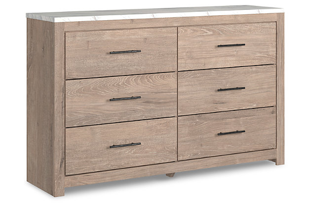 Cool, clean and casually modern. The Senniberg dresser’s light natural finish and faux Calcutta marble top set the tone for your calming sanctuary. Large linear pulls add dimension and authenticity. Six smooth-gliding drawers neatly accommodate your wardrobe needs.Dresser only | Made of engineered wood (MDF/particleboard) | and decorative laminate | Dry, light finish with replicated oak grain and authentic touch | Replicated Calcutta marble top | 6 smooth-gliding drawers with faux linen lining | Large scale dark colored handles | Safety is a top priority, clothing storage units are designed to meet the most current standard for stability, ASTM F 2057 (ASTM International) | Drawers extend out to accommodate maximum access to drawer interior while maintaining safety | Assembly required