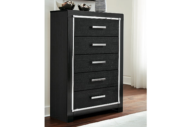Rest easy. The luxurious look you’ve been dreaming of is yours for the taking, at a price sure to put you at ease. The Kaydell chest of drawers’ deep, dark finish, faceted chrome-tone accents and faux alligator panels exude Hollywood-chic style to the max. Sure to entice those with refined tastes, this chest is a contemporary masterpiece.Made of engineered wood (MDF/particleboard) and decorative laminate | Replicated walnut wood grain | Textured faux alligator panels | Chrome-tone faceted accents | 5 smooth-gliding drawers with faux linen lining and large chrome-tone pulls with faceted details | Safety is a top priority, clothing storage units are designed to meet the most current standard for stability, ASTM F 2057 (ASTM International) | Drawers extend out to accommodate maximum access to drawer interior while maintaining safety | Assembly required